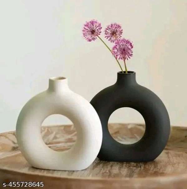 New Ring PCENFAP015 Planter (Pack of 2, 5 Inch, Black and White)Name: New Ring Planter (Pack of 2, 5 Inch, Black and White)Material: CeramicColor: BlackProduct Length: 10 cmProduct Height: 10 cmProduct Breadth: 10 cmNet Quantity (N): 2 seamlessly blends elegance with functionality. Its smooth surface, kissed by gentle curves, cradles verdant life with grace. 
