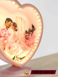 personalized heart-shaped LED photo frame with decorative floral elements, similar to products offered by brands like ND Enterprise or Archies.