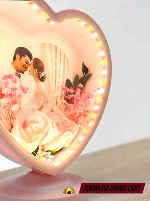 personalized heart-shaped LED photo frame with decorative floral elements, similar to products offered by brands like ND Enterprise or Archies.