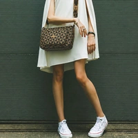 This Storite women's crossbody sling bag features a coffee-colored geometric monogram pattern and a gold-toned logo plaque.