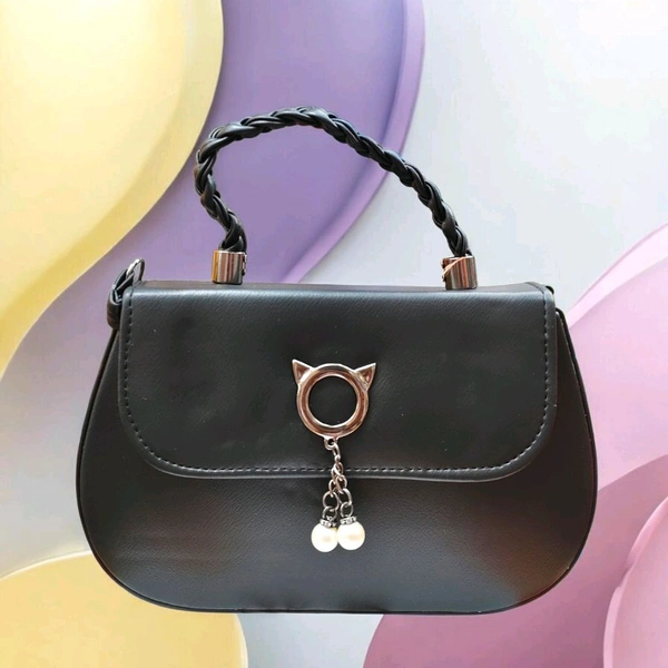 This black faux leather sling bag features a unique cat-ear hardware accent and a braided top handle.