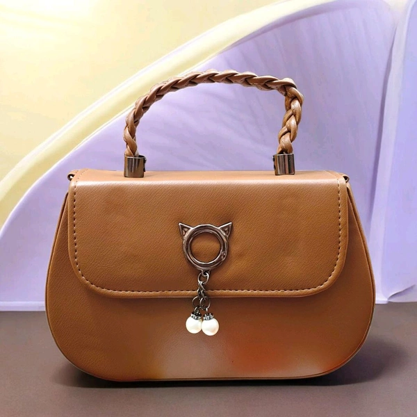 This BROWN faux leather sling bag features a unique cat-ear hardware accent and a braided top handle.