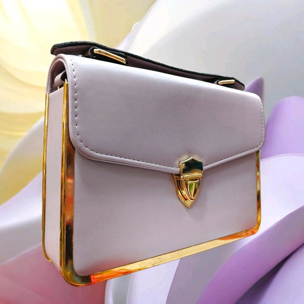 This Light Purple faux leather crossbody satchel by The Rare Bird features a metallic gold frame accent and a turn lock closure.