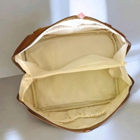 This brown PU leather cosmetic bag is branded with "ROSE OF NO MAN'S LAND.
