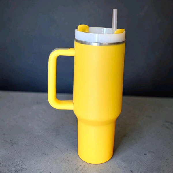 This yellow Enem tumbler features a matching lid, built-in straw, and a side handle for easy carrying.