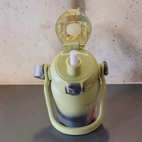 This is a Mumiguan 44-ounce insulated water bottle featuring a grey-green gradient design and a top carry handle.
