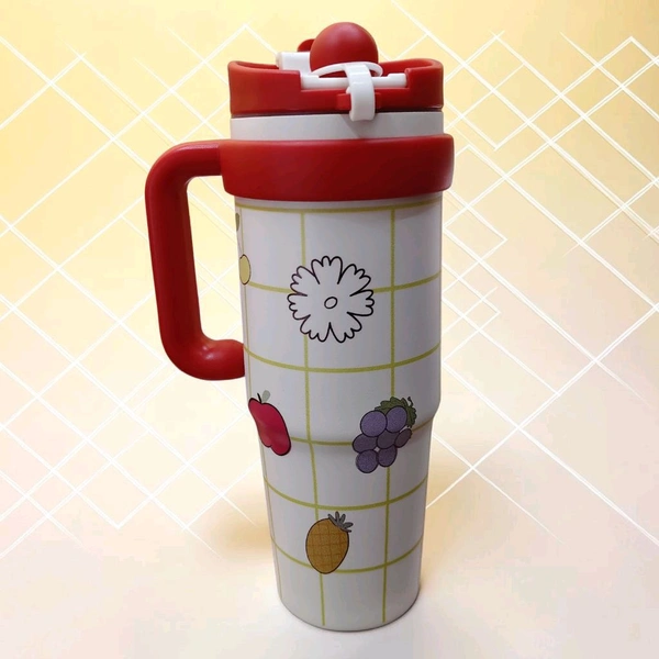 This red and white tumbler features a fruit-themed grid pattern, a prominent handle, and a flip-top lid